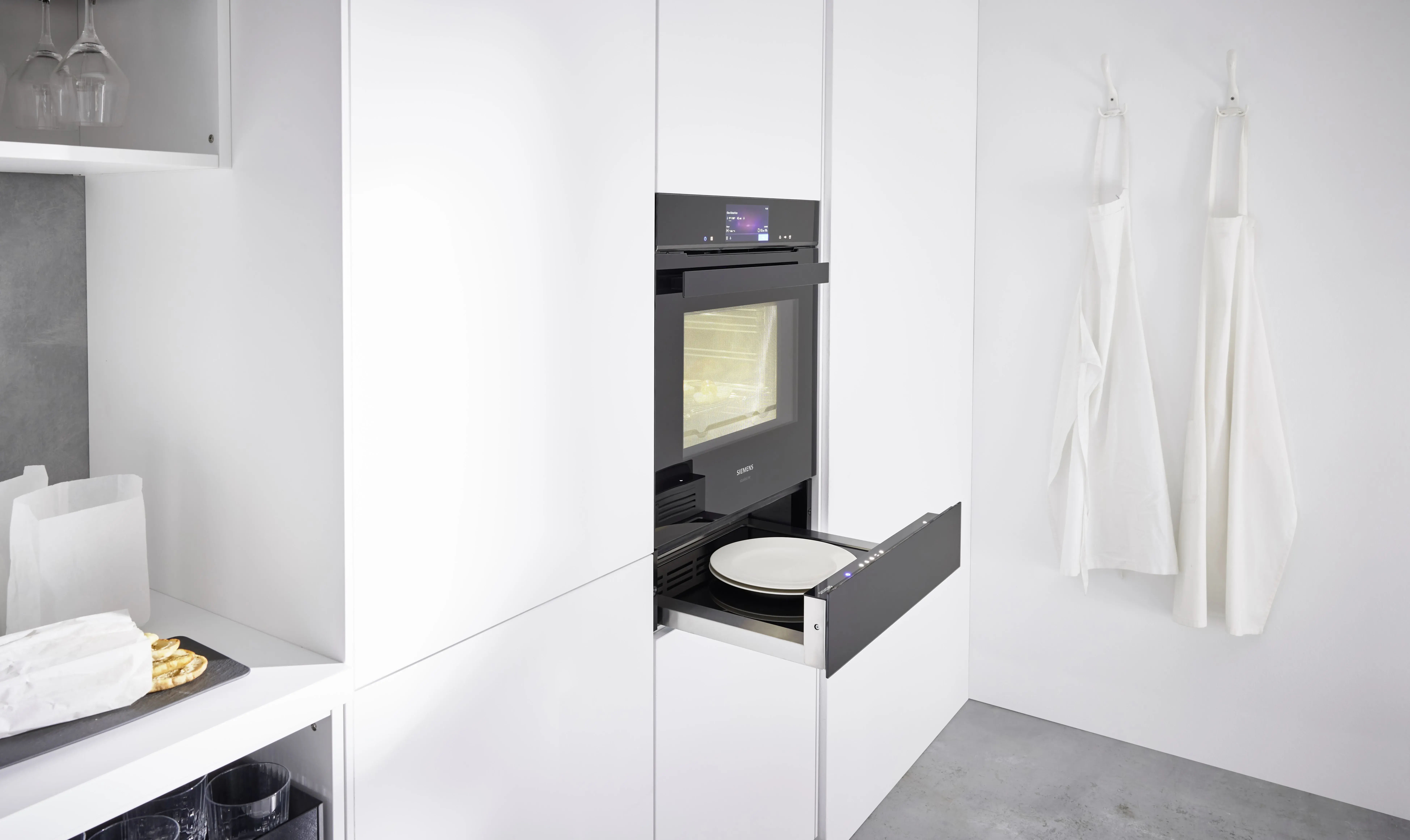 NOBILIA Alpinweiß mit Siemens Geräten - Fokus auf Backofen mit Wärmeschublade geöffnet