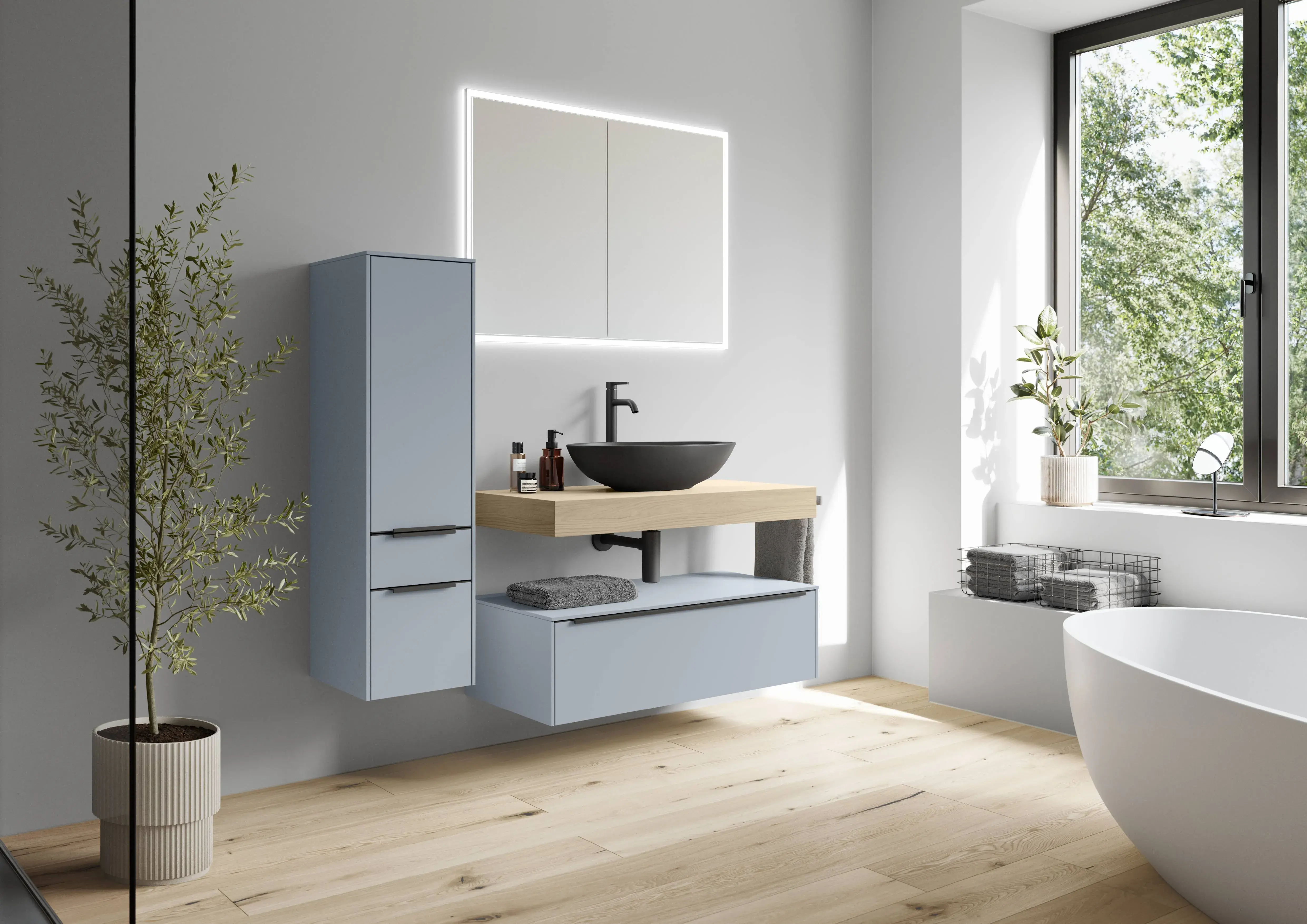 Modernes Badezimmer mit blauen Badmöbeln, Holzwaschtisch, schwarzem Aufsatzwaschbecken, LED-Spiegel und freistehender Badewanne