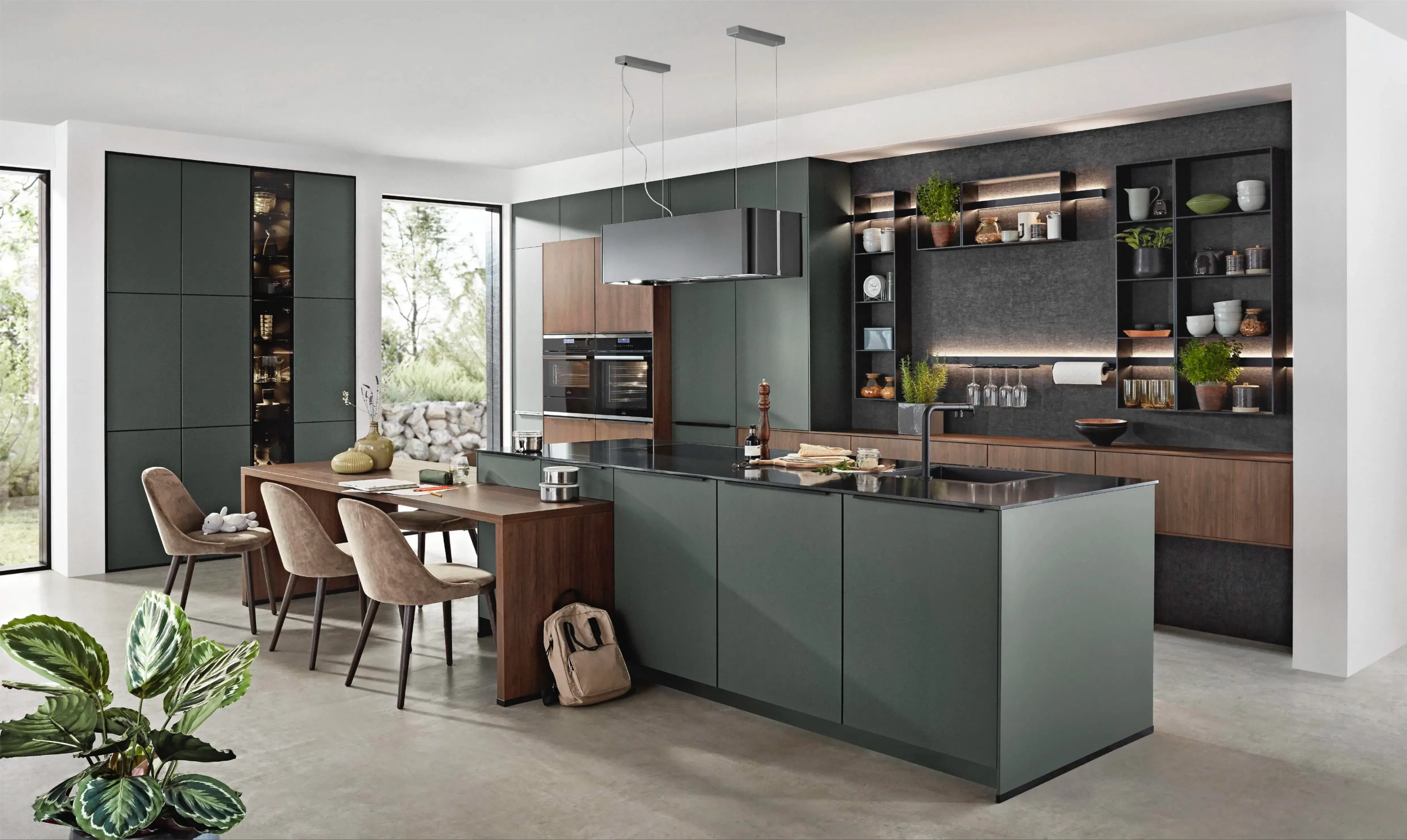 Moderne Designküche in Dunkelgrün und Holz mit großer Kochinsel, integriertem Essbereich und offenen beleuchteten Regalen