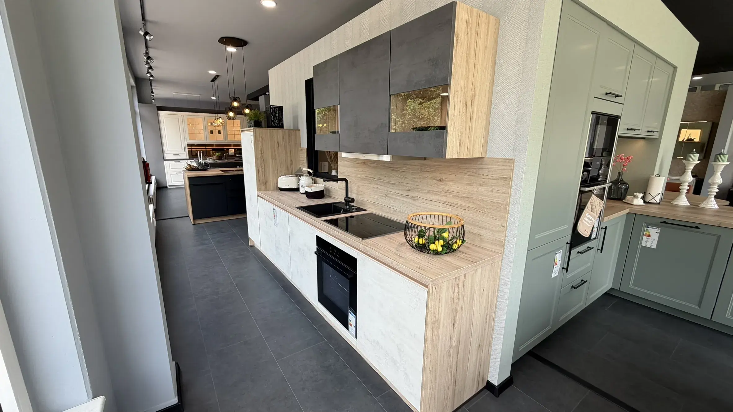 Moderne Küche in Holz- und Betonoptik mit schwarzen Akzenten, integrierten Elektrogeräten und grifflosen Fronten
