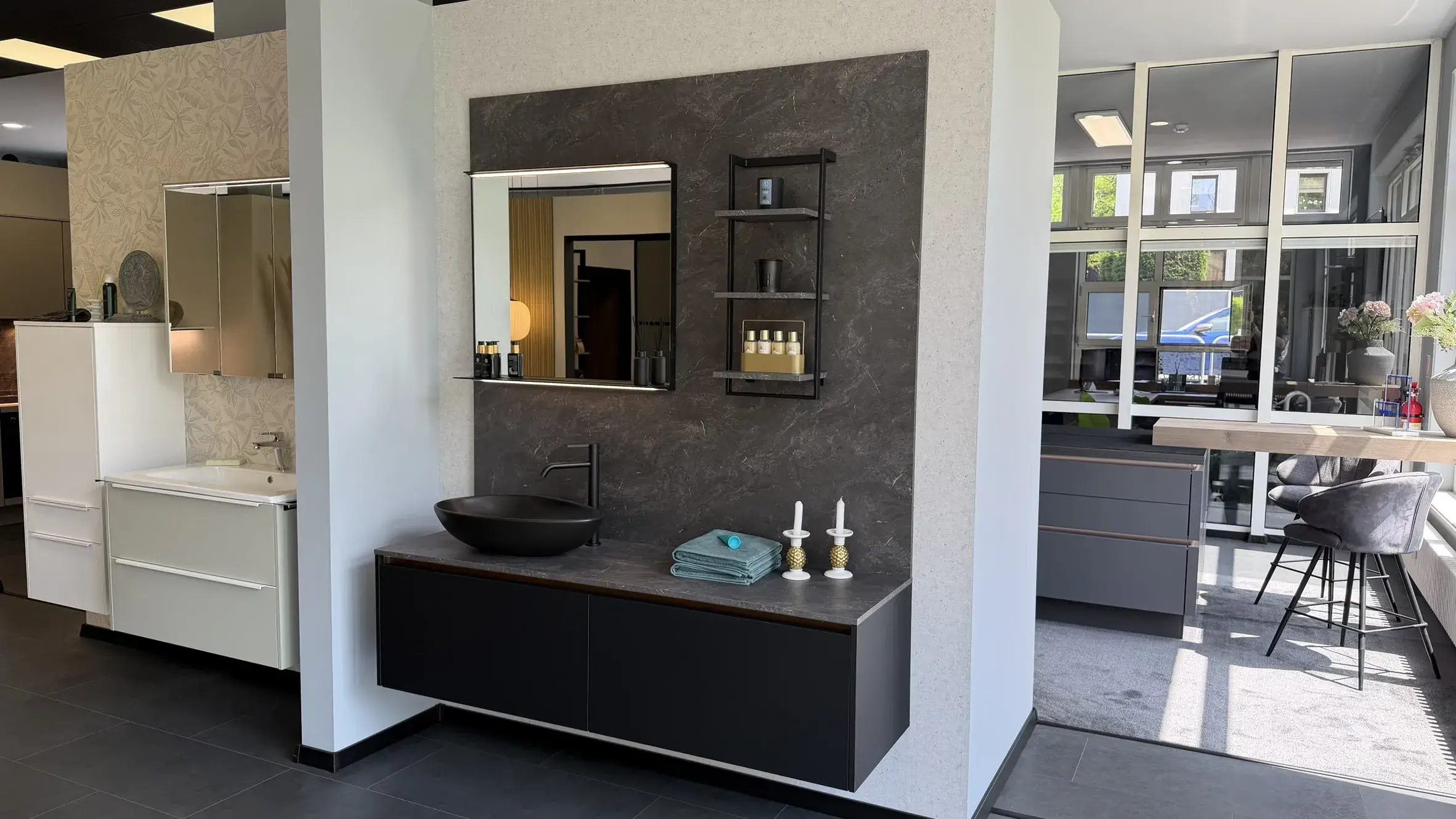 Modernes Badezimmer mit schwarzem Waschtisch, Aufsatzwaschbecken und dunkler Wandverkleidung in Natursteinoptik