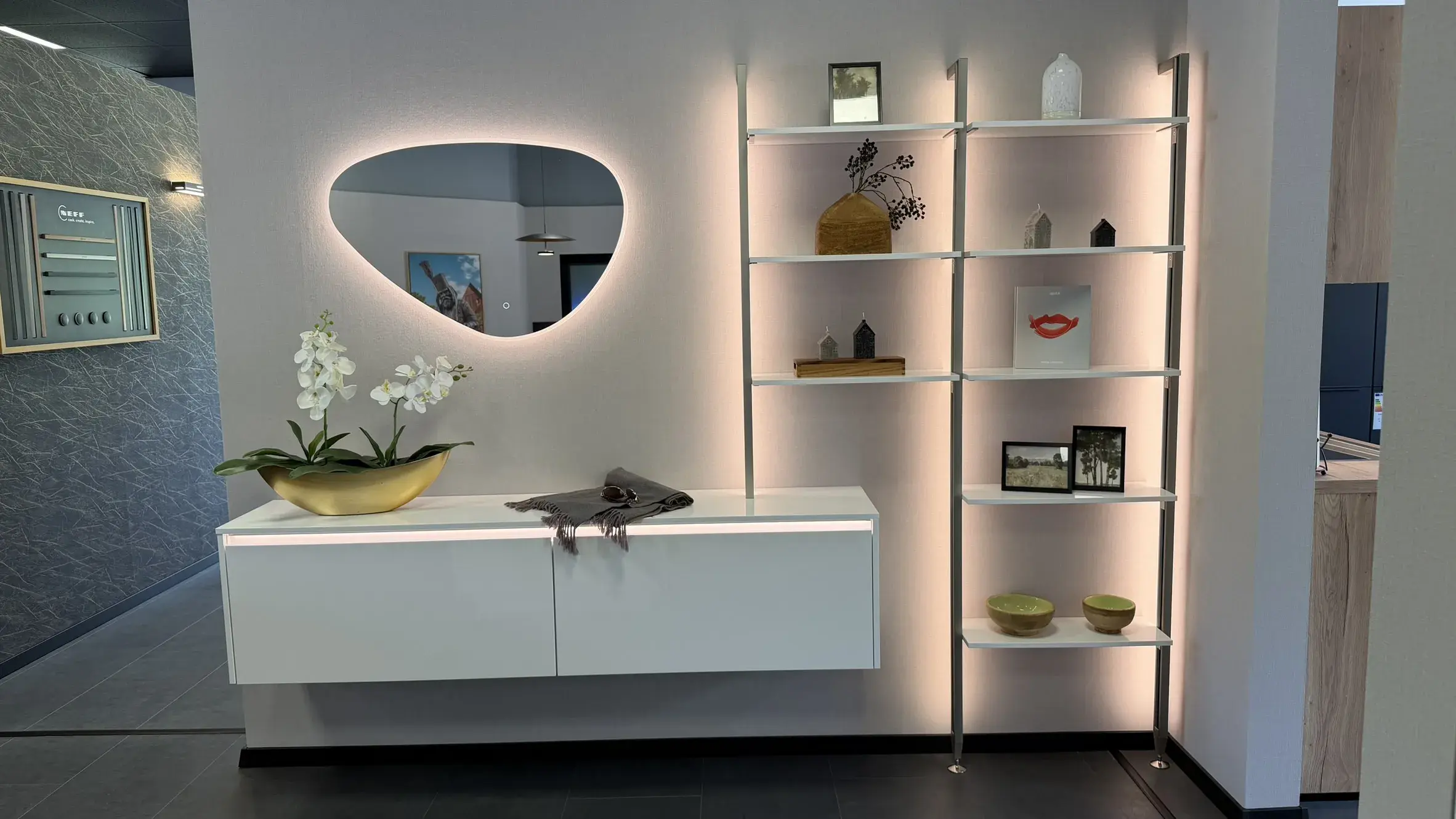 Moderner Wohnbereich mit schwebendem Sideboard, beleuchtetem Spiegel und offenem Designregal