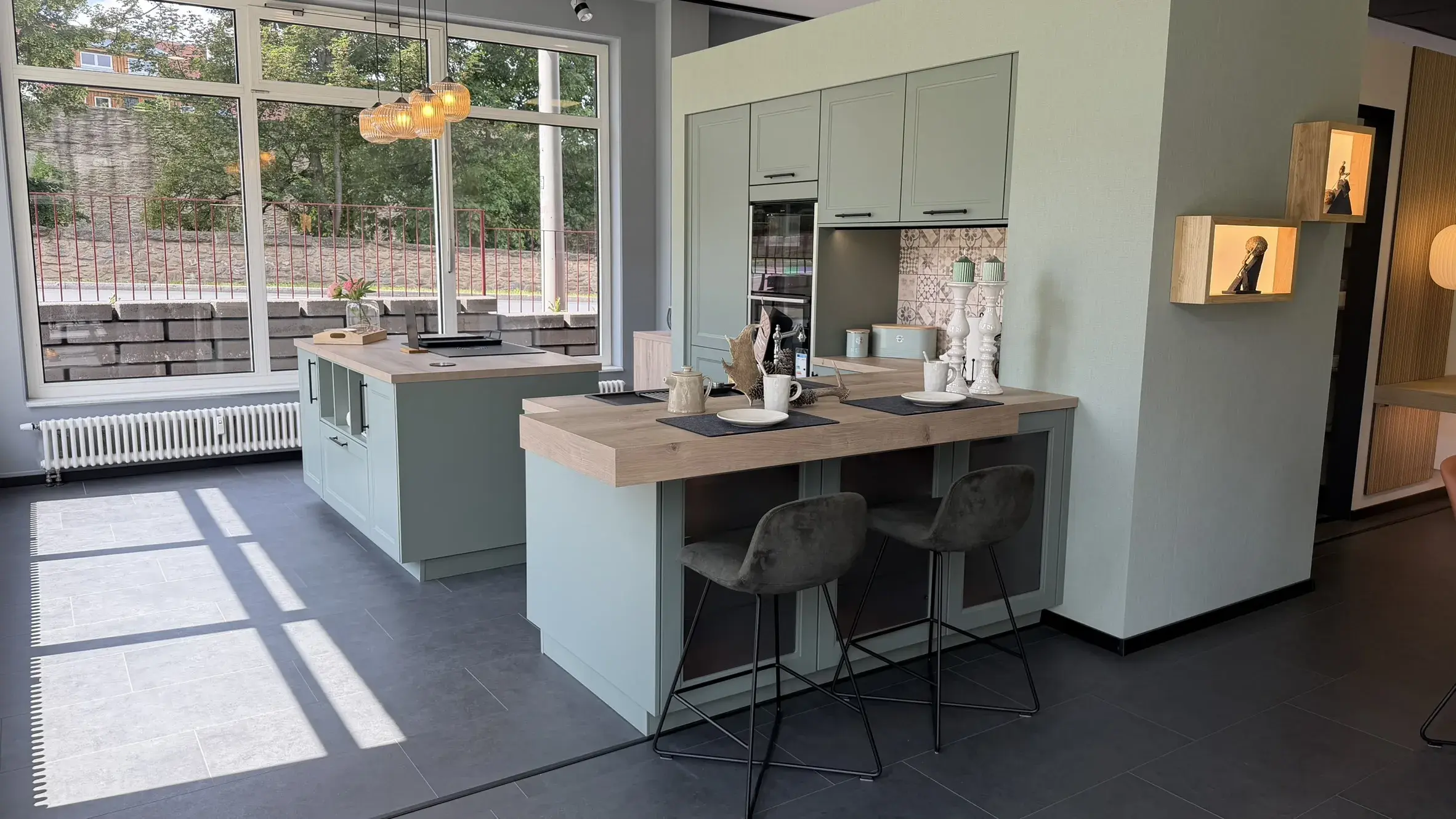 Moderne Landhausküche in Salbeigrün mit Kochinsel, integriertem Essplatz und Arbeitsplatte in Holzoptik